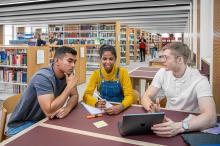 Studierende sitzen am Arbeitsplatz in der Universitätsbibliothek