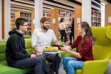 Studierende und Professor in der Universitätsbibliothek