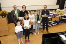 Fünf Kinder mit Auszeichnungen stehen in einer Reihe, daneben zwei Erwachsene aus dem Organisationsteam.