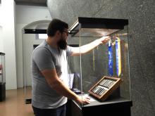 Masterstudent Bernd Spila bei letzten Handgriffen an einer von ihm konzipierten Ausstellungsvitrine.