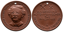 Medaille mit einem Kopfbild von Karl Julius Braunsdorf sowie Schlägel und Eisen neben Hüttenbesteck 