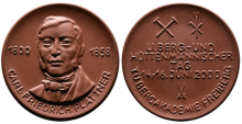Medaille mit einem Brustbild von Carl Friedrich Plattner sowie Schlägel und Eisen neben Hüttenbesteck 