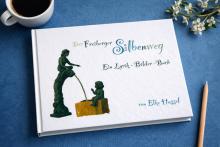 Bild zeigt ein Buch auf einem Tisch mit einem Bleistift, einer Tasse Kaffee und Blumen.