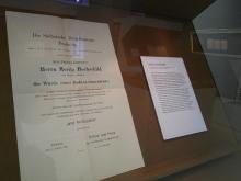 Blick in eine Ausstellungsvitrine, zu sehen ist die Promotionsurkunde von Moritz Hochschild